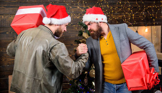 男人戴着圣诞老人的帽子, 盛放礼品盒。带着胡子的人拿着礼物的箱子。残忍的嬉皮士们带着礼物庆祝圣诞节。交付圣诞礼物。圣诞节就要到了