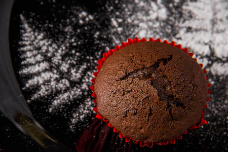 黑背景下的巧克力松饼加糖霜图片