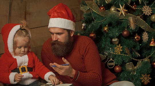 圣诞老人男孩和胡子的人在圣诞节树