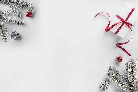 圣诞礼品盒白色背景与杉树枝松果红色装饰。 圣诞节和新年快乐主题。 平躺顶部视图空间文本