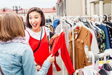 两个女朋友一起购物，选择生动的衣服购买。