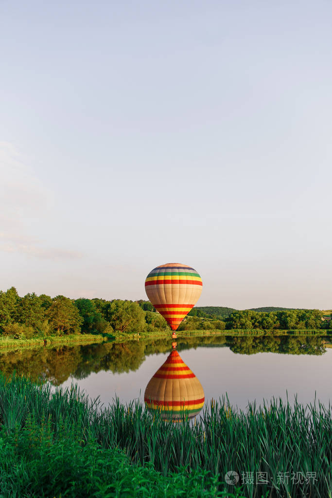 多种颜色的热气球在靠近水的湖面上飞行. 在大自然中膨胀.照片-正版商