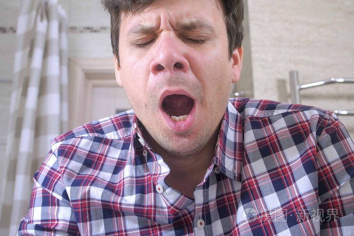 早上在浴室宿醉的年轻人打哈欠