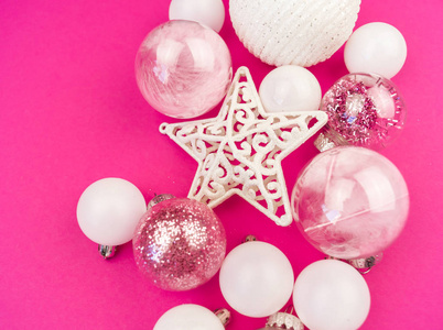 粉红色背景上温和的粉红色和白色的鲍布。 圣诞节的心情。 节日装饰。 亮片和闪光的派对。
