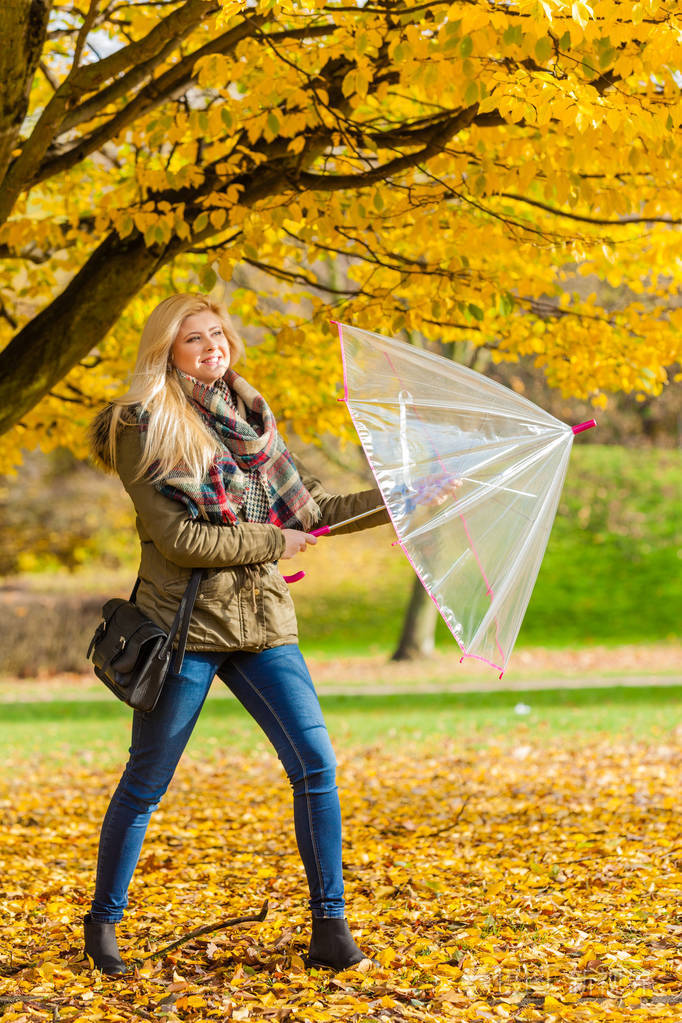 放松的外部概念女人带着雨伞在公园里散步秋天的晴朗天气