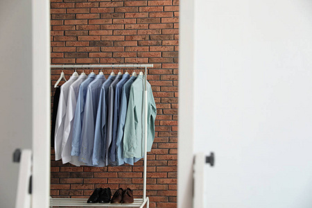 s clothes near brick wall in mirror at home. Space for text