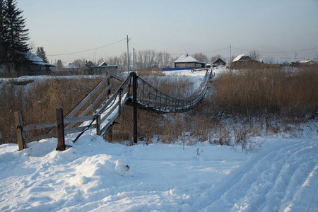 俄罗斯西伯利亚大自然冬季霜冻寒冷的乡村森林泰加雪路家园安静的桥河冰岸冬季景观傍晚反射日