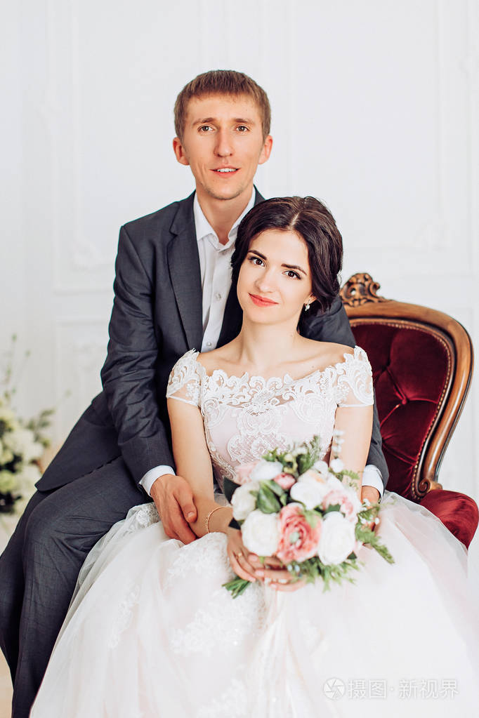 美丽年轻的新娘新郎在房间里摆姿势
