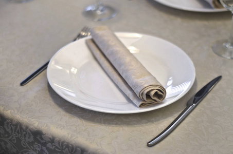 室内的漂亮菜肴。 美丽的桌子设置与刀，勺子和盘子在内部的咖啡馆和餐厅。