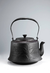 轻背景上的古董铁茶壶