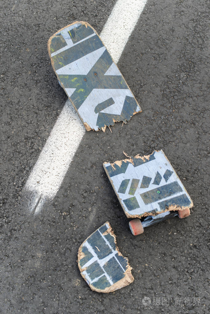 在黑暗的沥青街上破碎的滑板白色街道线