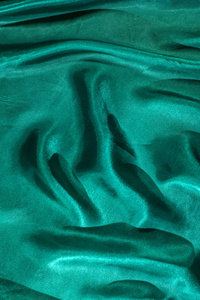 绿色缎子织物的背景。 闪亮的绿色丝绸背景。