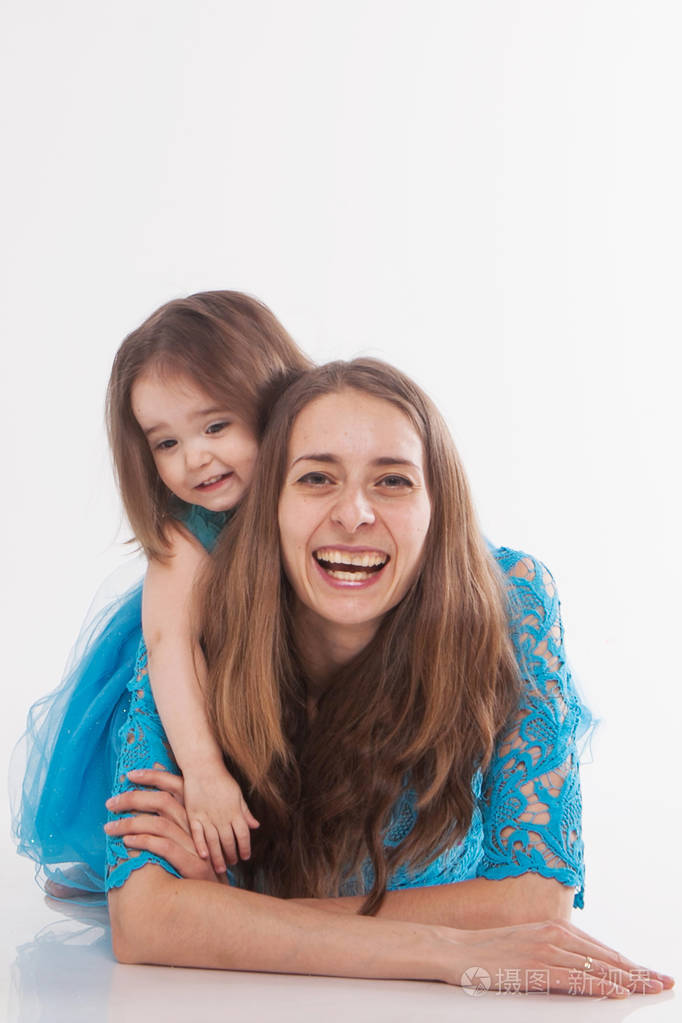 母亲和孩子在白色背景上摆姿势穿蓝色裙子的女人
