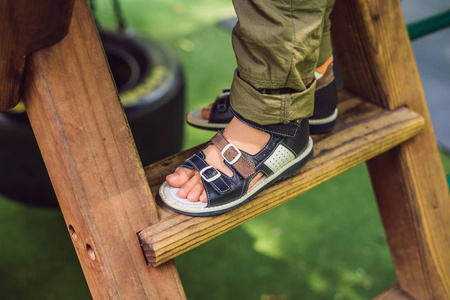 穿着矫形凉鞋的男孩在操场上玩耍照片