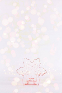 一排雪花铜饼干切割机在白色闪闪发光的背景与波克灯。 节日圣诞节和新年背景。 垂直明亮的灯光背景