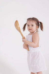 小女孩手里拿着勺子，白色背景上的隔离照片