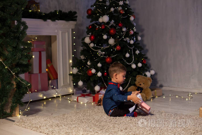 男孩打开圣诞礼物新年圣诞树加兰灯