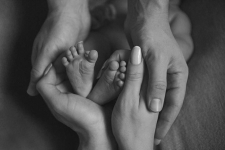 s feet.Mother holding newborn baby legs,legs massage