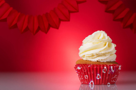 s day. Delicious cupcakes in a red basket on bright background