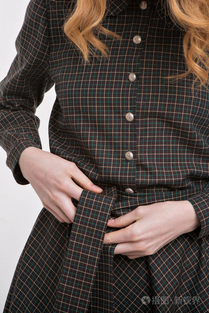 女孩把腰带系在裙子上手在织物背景关闭衣服的元素