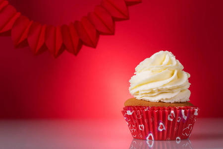 s day. Delicious cupcakes in a red basket on bright background