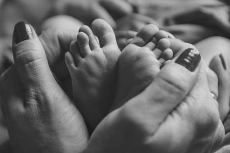 s feet.Mother holding newborn baby legs,legs massage