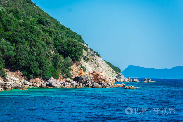 沿海山景,覆盖着茂盛的绿色植物,有大海和蓝天