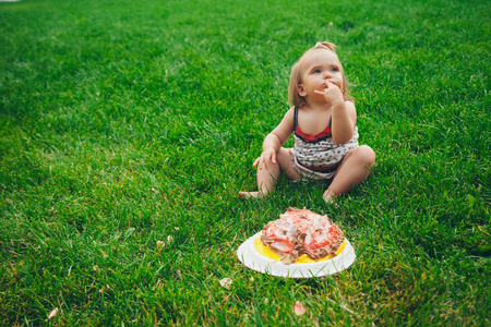 草地上有蛋糕的小女孩的肖像