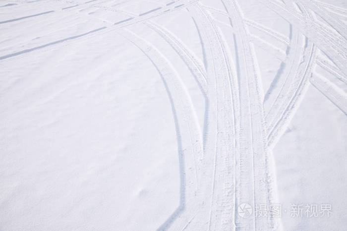 汽车轮胎在鲜雪中的相交弧线痕迹