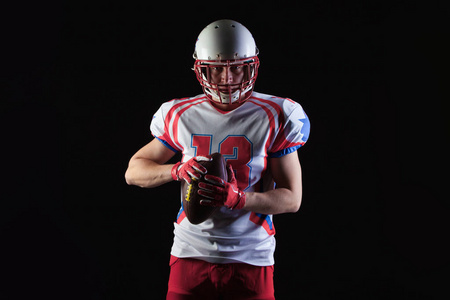 美国足球运动员戴着头盔准备在黑色背景上投球