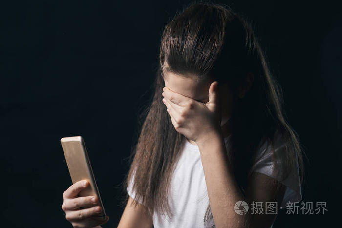 年轻的悲伤脆弱的女孩使用手机害怕和绝望的痛苦在线滥用网络被跟踪