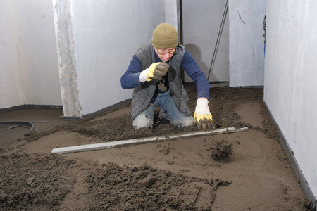 建筑地盘的建筑工人浇混凝土照片