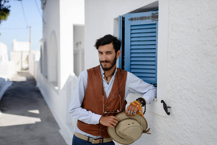 一个四十个人的肖像,站在卫城之上,戴着一顶希腊水手帽,俯瞰雅典希腊