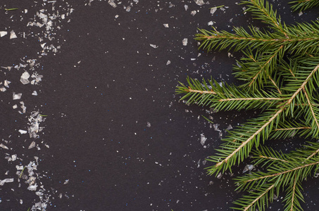 圣诞框架由松树枝和雪花在黑色背景。
