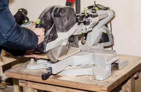 s machine with circular saw, man cuts the board. Work process, e