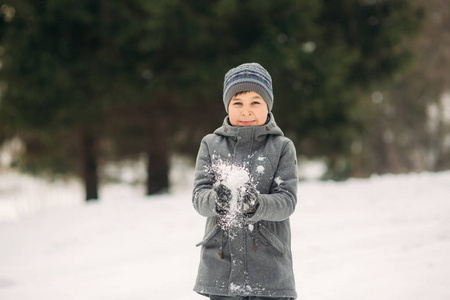 冬天的天气里, 一个小男孩在公园里散步, 玩雪球和高兴。等待圣诞节的心情