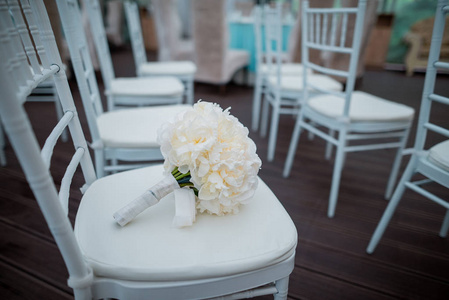 白色椅子婚礼装饰上的新娘花束图片