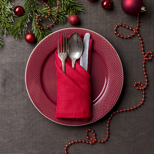 s serving red plate, with fork, spoon and knife in red napkin wi