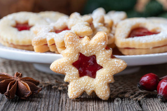 传统的林泽圣诞饼干，在乡村背景上装满草莓果酱