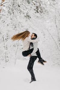 一对相爱的夫妇在雪地森林里拥抱亲吻和享受。