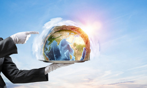 s hand in white glove presenting Earth globe on metal tray and p