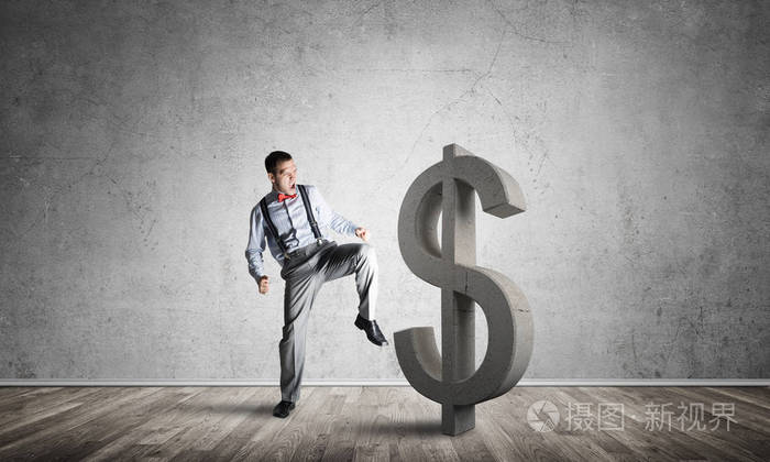 年轻暴怒的商人将用踢石美元符号崩溃照片-正版商用图