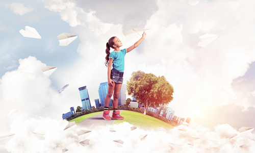 扔纸飞机城市浮岛扔纸飞机的可爱小女孩照片