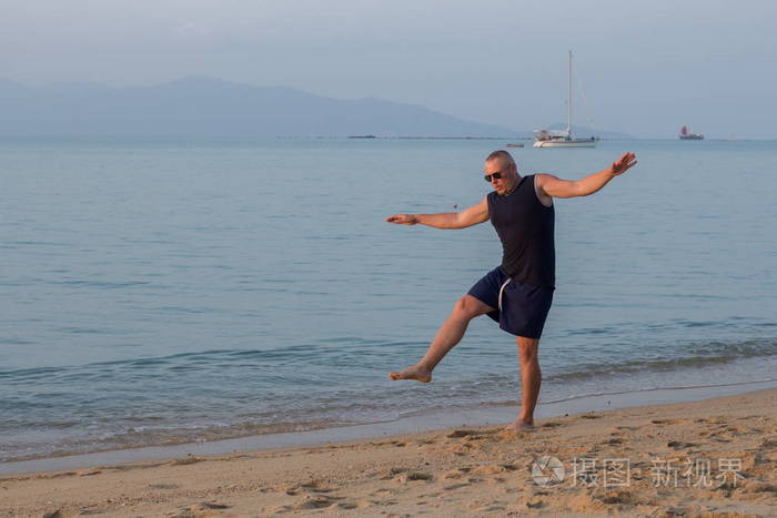 情绪激动的人在沙滩上的水面上摆姿势