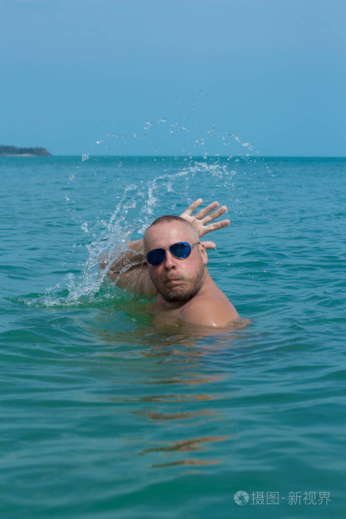 情绪激动的人在沙滩上的水面上摆姿势