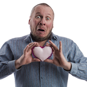 玩具的情绪一个情绪激动的演员,穿着灰色衬衫,手里拿着一颗柔软的玩具