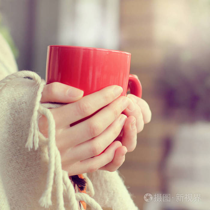 红色杯子,手里拿着热饮料,裹着毯子/温暖的家庭气氛