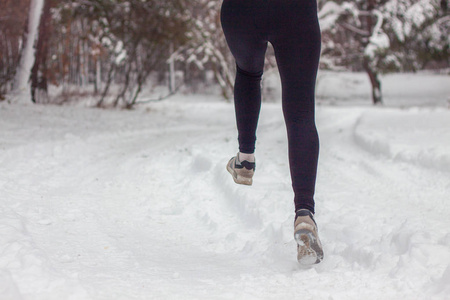 在新鲜空气中的树林里进行冬季运动。 雪上运动鞋的特写。