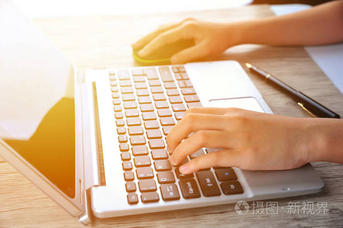 手拿笔记本电脑在阳光下打字