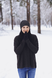 冬雪森林里穿着毛衣的年轻美丽的黑发女孩